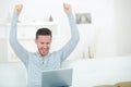 Man using laptop making triumphant gesture
