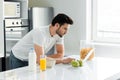 Man using laptop near cereals, milk and orange juice