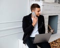 A man using laptop near fireplace. Royalty Free Stock Photo