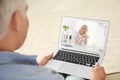 Man using laptop for online consultation with doctor via video chat at home