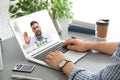 Man using laptop for online consultation with doctor via video chat at table Royalty Free Stock Photo