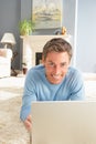 Man Using Laptop Relaxing Laying On Rug At Home Royalty Free Stock Photo