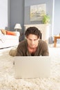 Man Using Laptop Relaxing Laying On Rug At Home Royalty Free Stock Photo