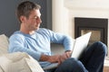 Man Using Laptop Relaxing Sitting On Sofa At Home Royalty Free Stock Photo