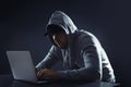 Man using laptop at table on dark background Royalty Free Stock Photo