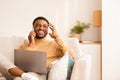 Man Using Laptop Talking On Phone Sitting On Sofa Indoor Royalty Free Stock Photo