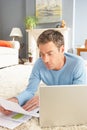 Man Using Laptop To Manage Bills Laying On Rug Royalty Free Stock Photo