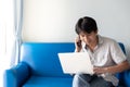 A man using laptop for works and online activities while talking on mobile phone and sitting for business discussion