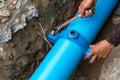 Man using a large wrench on water pipes. Construction site with new Water Pipes in the ground. Sewer pipes to repair or restore in