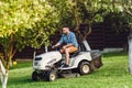 Man using lawn tractor for mowing grass in household garde Royalty Free Stock Photo