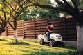 Man using lawn tractor for mowing grass. Landscaping works with professional tools