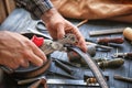 Man using leather punch while working with belt at factory, closeup