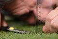 Man Using Measuring Scale While Cutting Grass Royalty Free Stock Photo