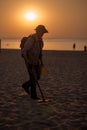 Man using a metal detector on the beach