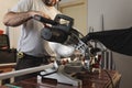 Man using a miter saw to cut aluminum profiles for the construction of windows and doors. Carpentry. Industry. Horizontal image