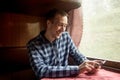 Man using mobile application on his smartphone at train station, business travel. Royalty Free Stock Photo