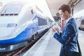 Man using mobile application on his smartphone at train station Royalty Free Stock Photo