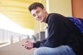 Man using mobile application on his smartphone at train station, travel. Handsome in railway station. Smile freelance man.