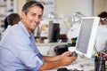 Man Using Mobile Phone At Desk In Busy Creative Office Royalty Free Stock Photo