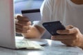 Man using mobile phone and laptop shopping online with credit card. Man holding credit card using smart phone for purchase or buy Royalty Free Stock Photo