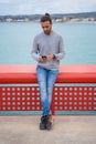 Man using mobile phone leaning on a red railing