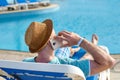 Man using mobile phone on vacation by the pool in hotel, concept of a freelancer working for himself on vacation and Royalty Free Stock Photo