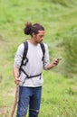 Man Using Mobile Phone Whilst Hiking In Countryside