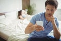 Man using mobile phone while woman sleeping on bed Royalty Free Stock Photo