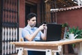 Man using a mobile phone while working with laptops trading cryptocurrencies outdoors