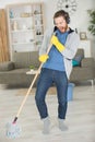 man using mop as microphone while doing housework Royalty Free Stock Photo
