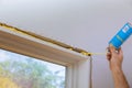 Man in a using a mounting foam window installation