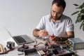 man using multimeter while fixing broken computer and looking down Royalty Free Stock Photo