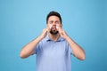 Man using nasal sprays on light blue background Royalty Free Stock Photo