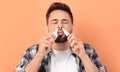 Man using nasal sprays on peach background Royalty Free Stock Photo