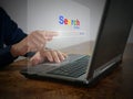 A man is using a notebook computer to searching for information. A virtual screen of the Search website browser for finding data