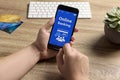 Man using online banking app on smartphone at wooden office table, closeup Royalty Free Stock Photo