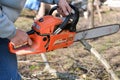 A man is using an orange chainsaw to cut tree branches Royalty Free Stock Photo