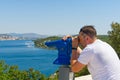 man using a panoramic telescope looking at the Mediterranean sea.