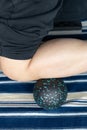 a man using peanut-shaped massage balls to relax his anterior tibialis at vertical composition