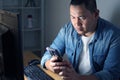 Man using phone application and working on his computer at night, online payment confirmation Royalty Free Stock Photo