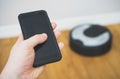 Man using phone to control hoover. Royalty Free Stock Photo