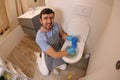 Man using plunger in the bathroom Royalty Free Stock Photo