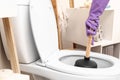 Man using plunger to unclog a toilet bowl Royalty Free Stock Photo