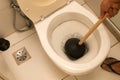 Man Using Plunger to unstop his toilet Royalty Free Stock Photo