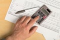 Man using pocket calculator with pen on financial analysis sheet background on wooden office desk - tax, finance or accounting Royalty Free Stock Photo