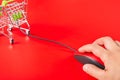 Man using red mouse connected to a shopping cart on red background Royalty Free Stock Photo