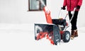 Man using red snowblower machine outdoor. Removing snow near house from yard Royalty Free Stock Photo