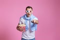 man using remote controller watching movie with big bucket of popcorns Royalty Free Stock Photo