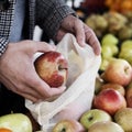 Man using a reusable mesh bag at a greengrocer