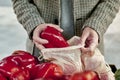 Man using a reusable mesh bag at a greengrocer